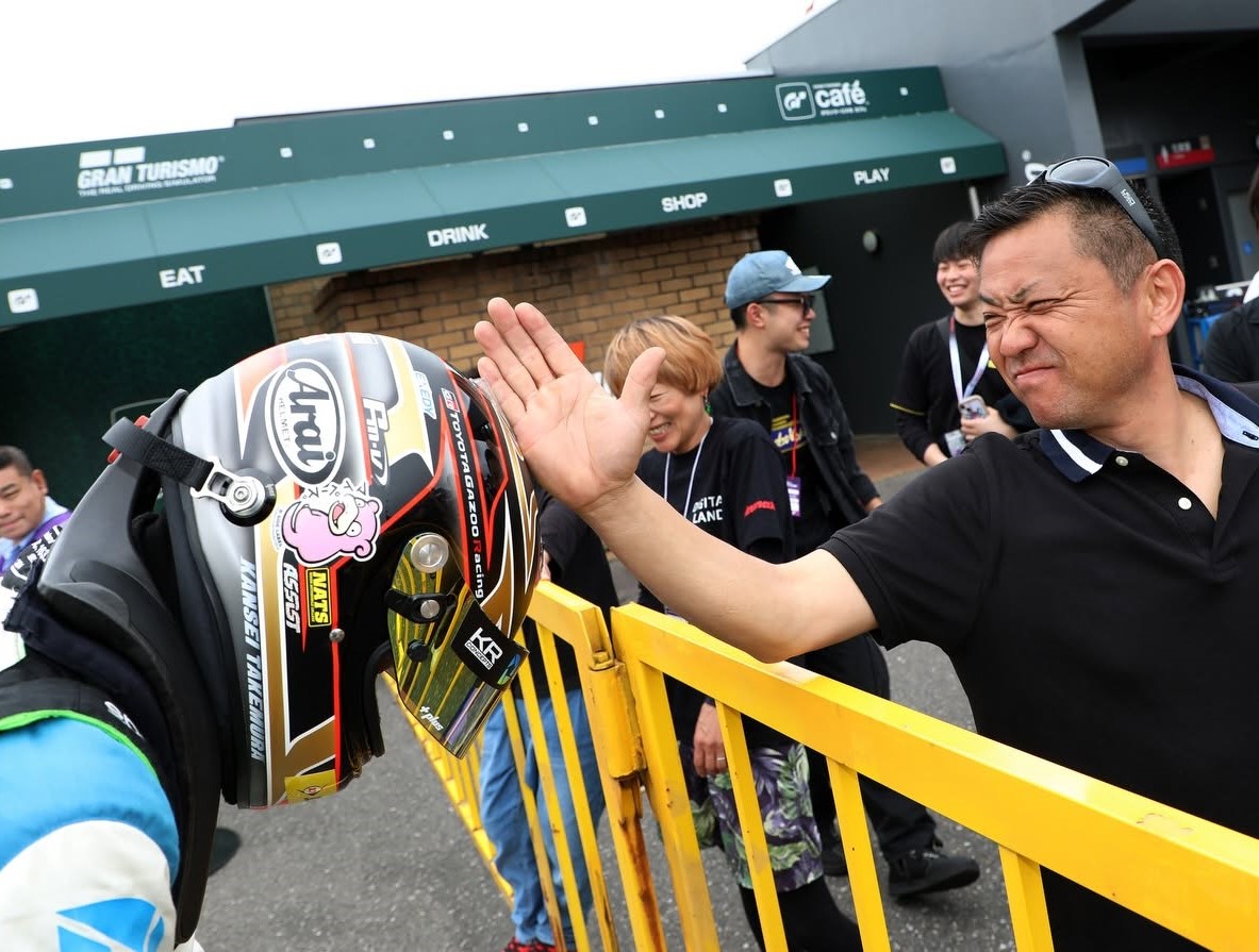 レース現場でドライバーと健闘を称え合う竹村代表